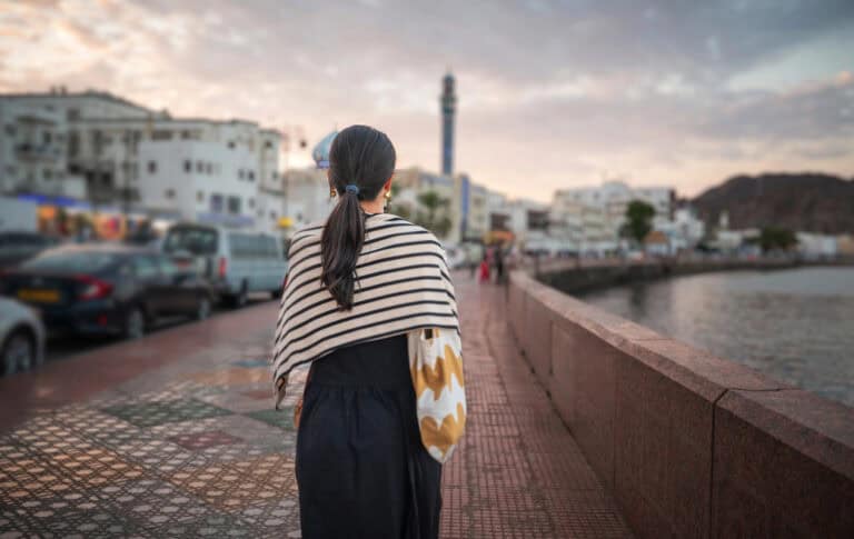 A woman walking alone along the Corniche in Matrah, Muscat.