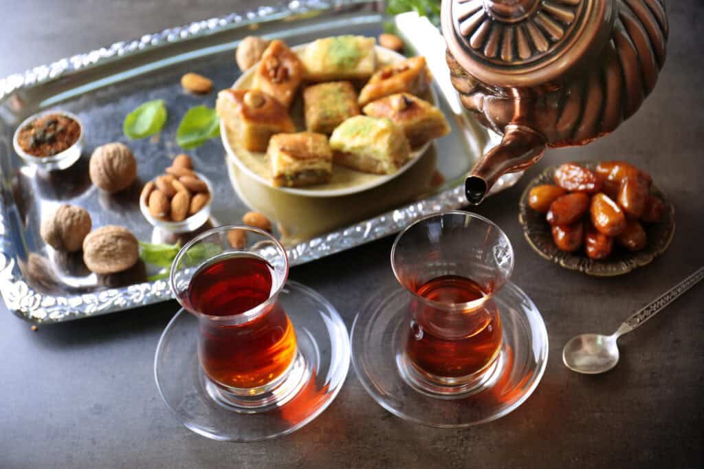 An array of Middle Eastern sweets served with tea.