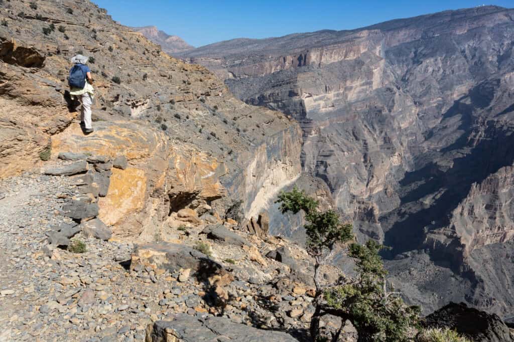a hiker at the edge of balcony Walk in Jabel Shams