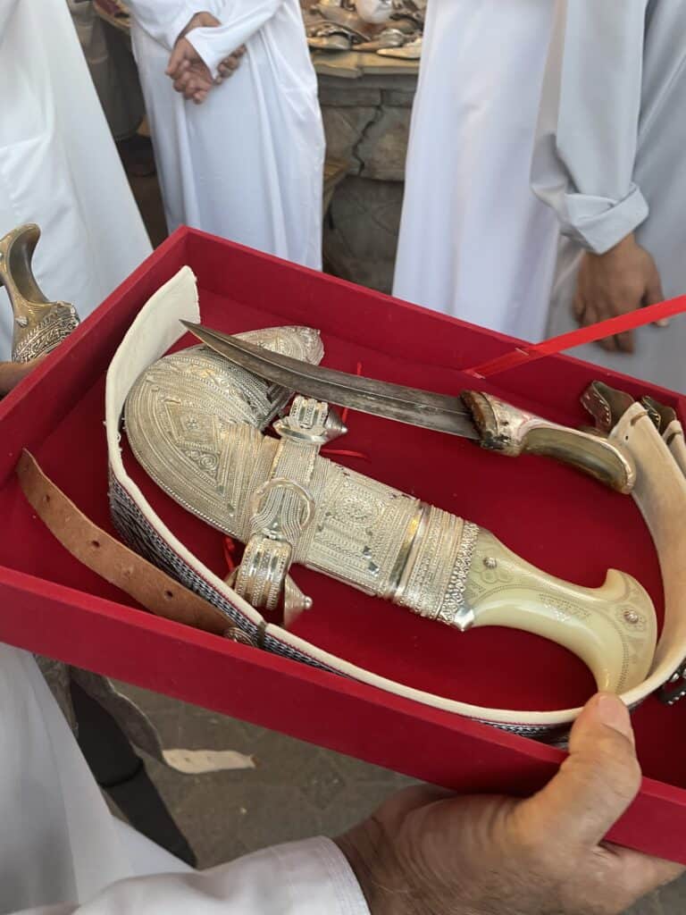 A silver Omani khanjar and belt displayed in a red box at the arms market in Nizwa Souq