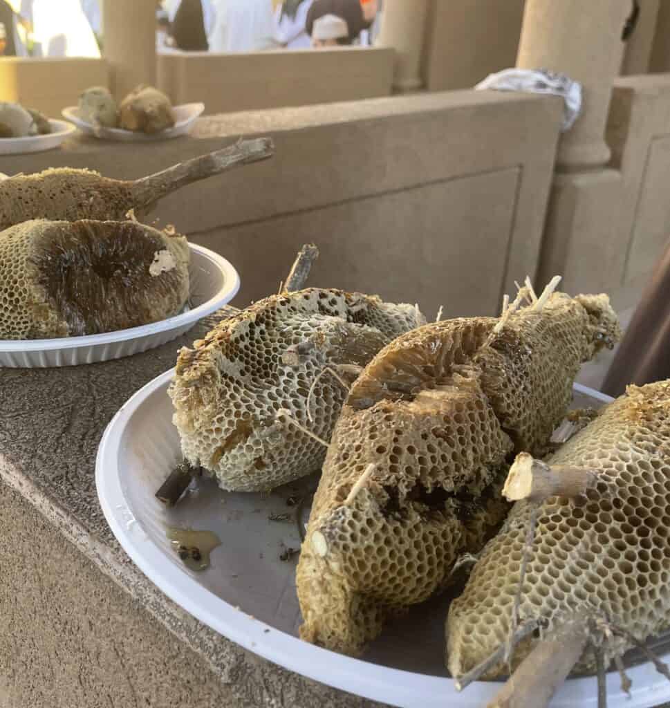 Fresh honeycomb pieces for sale on plates at the vegetable souq in Nizwa.
